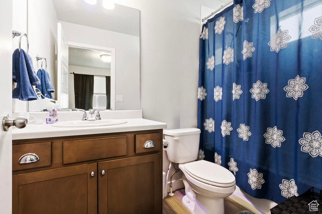 Full bath with toilet, vanity, and a shower with curtain