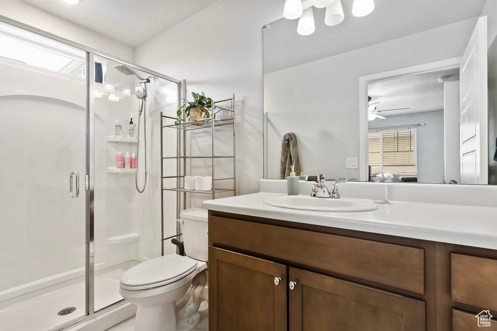 Bathroom with a shower stall, toilet, vanity, and plenty of natural light