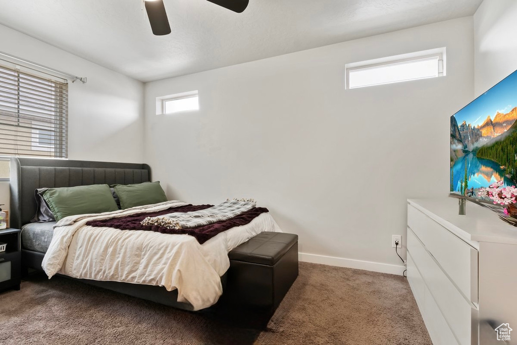 Carpeted bedroom with baseboards and a ceiling fan
