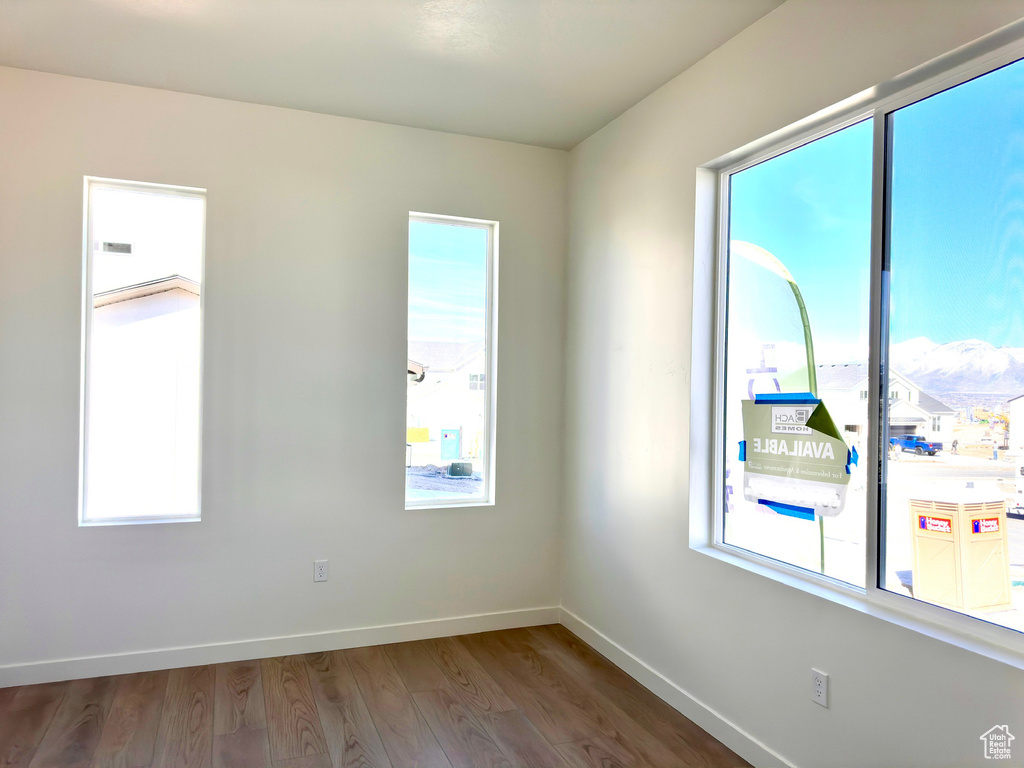 Unfurnished room featuring baseboards and wood finished floors