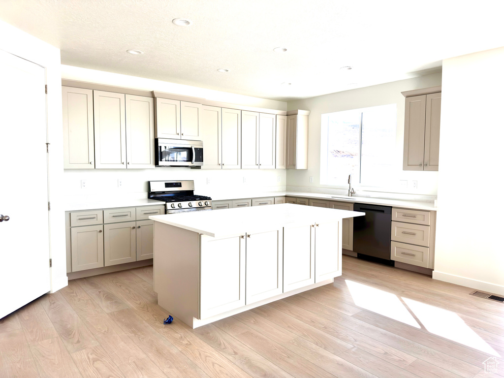 Kitchen featuring visible vents, a center island, light countertops, light wood-style flooring, and appliances with stainless steel finishes