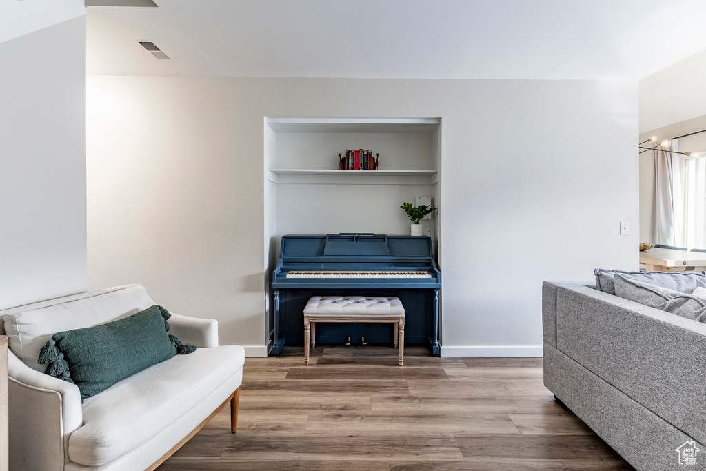 Living area featuring wood finished floors, visible vents, and baseboards