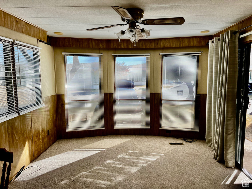 Unfurnished sunroom featuring ceiling fan