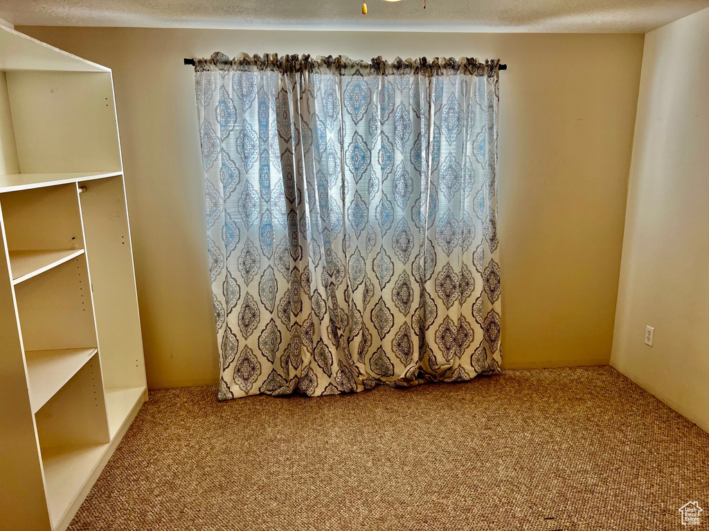 Carpeted spare room featuring a textured ceiling