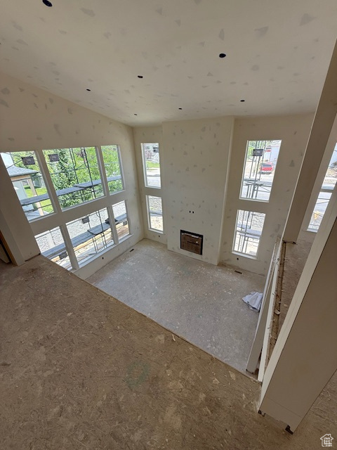 Unfurnished living room featuring plenty of natural light and a tiled fireplace