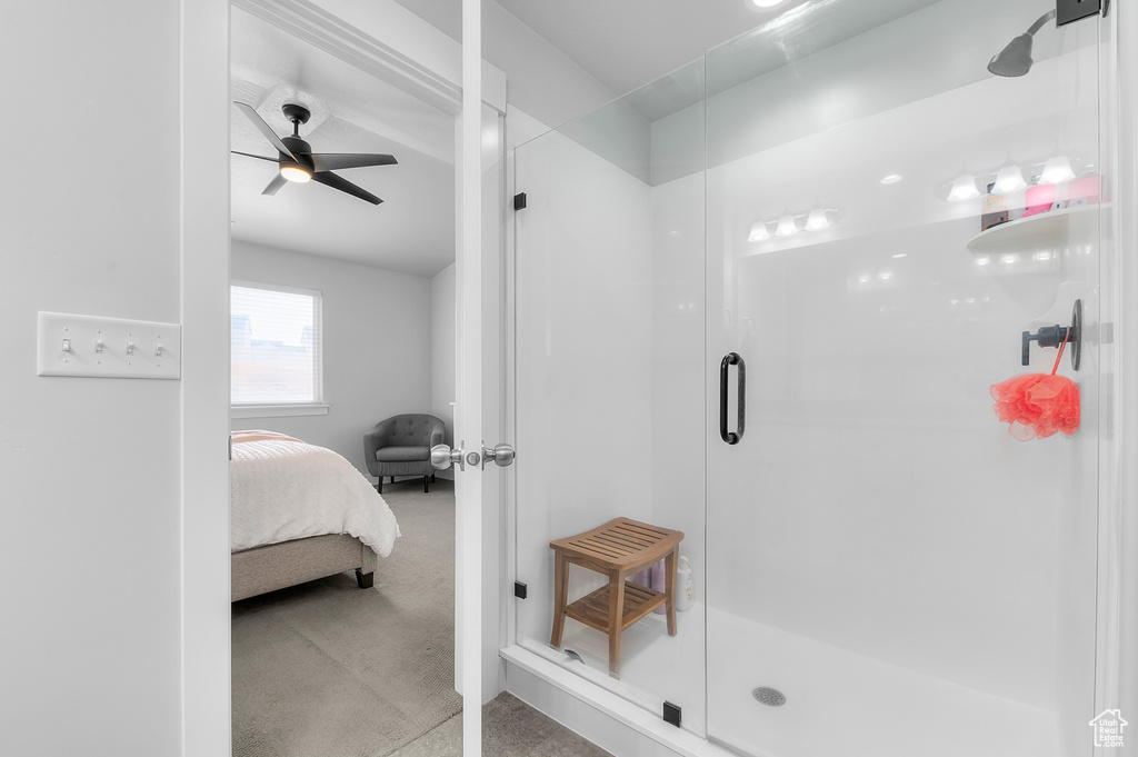 Bathroom featuring ceiling fan and a shower with shower door