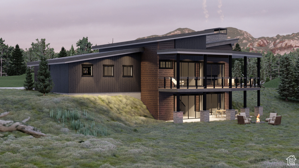 Rear view of property with a yard, a patio, a fire pit, and a deck with mountain view