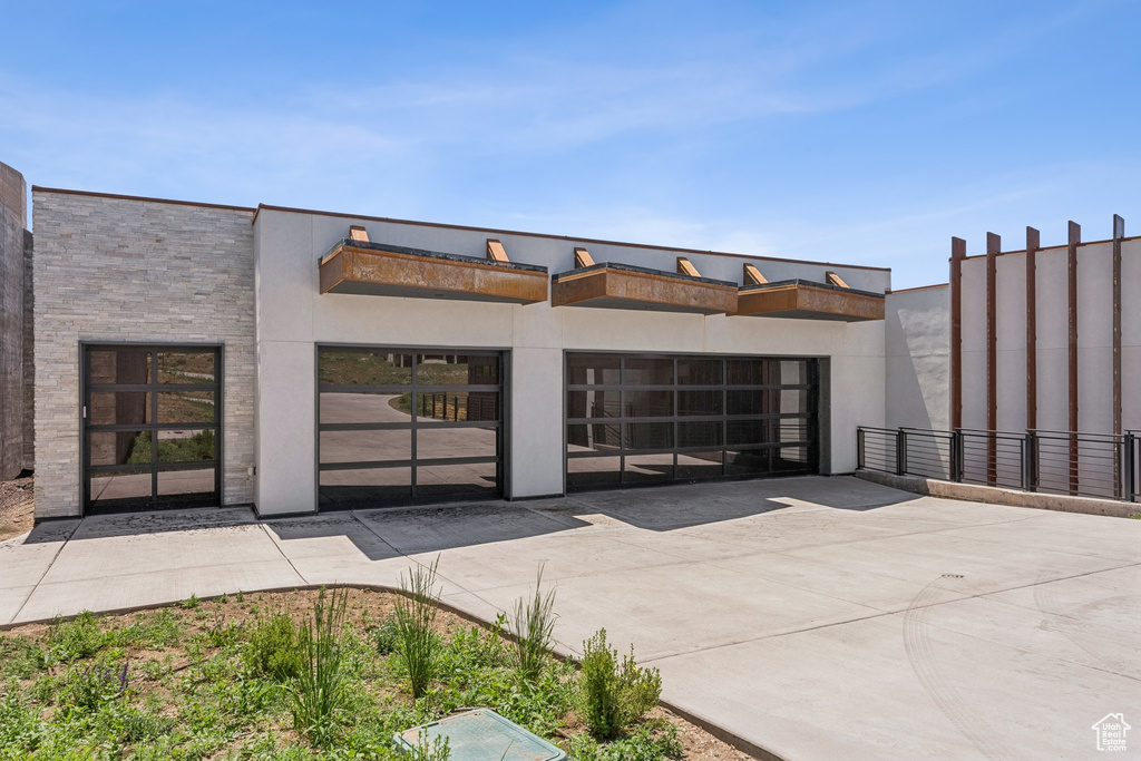 View of building exterior with driveway and an attached garage