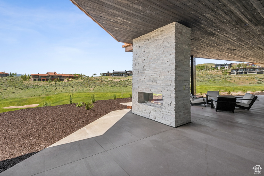 View of patio / terrace with an outdoor stone fireplace and a fire pit
