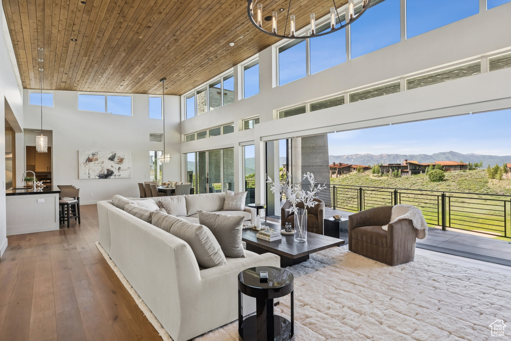 Living room featuring a towering ceiling, a mountain view, wooden ceiling, and hardwood / wood-style flooring