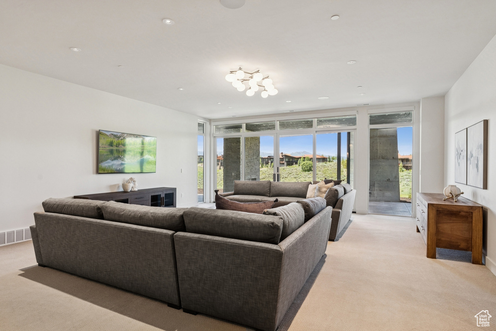 Living area featuring light colored carpet and floor to ceiling windows