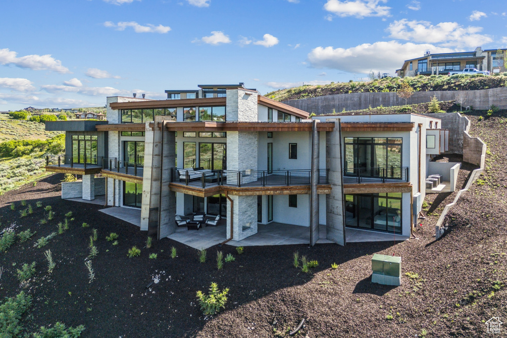 Rear view of house with a patio and a balcony