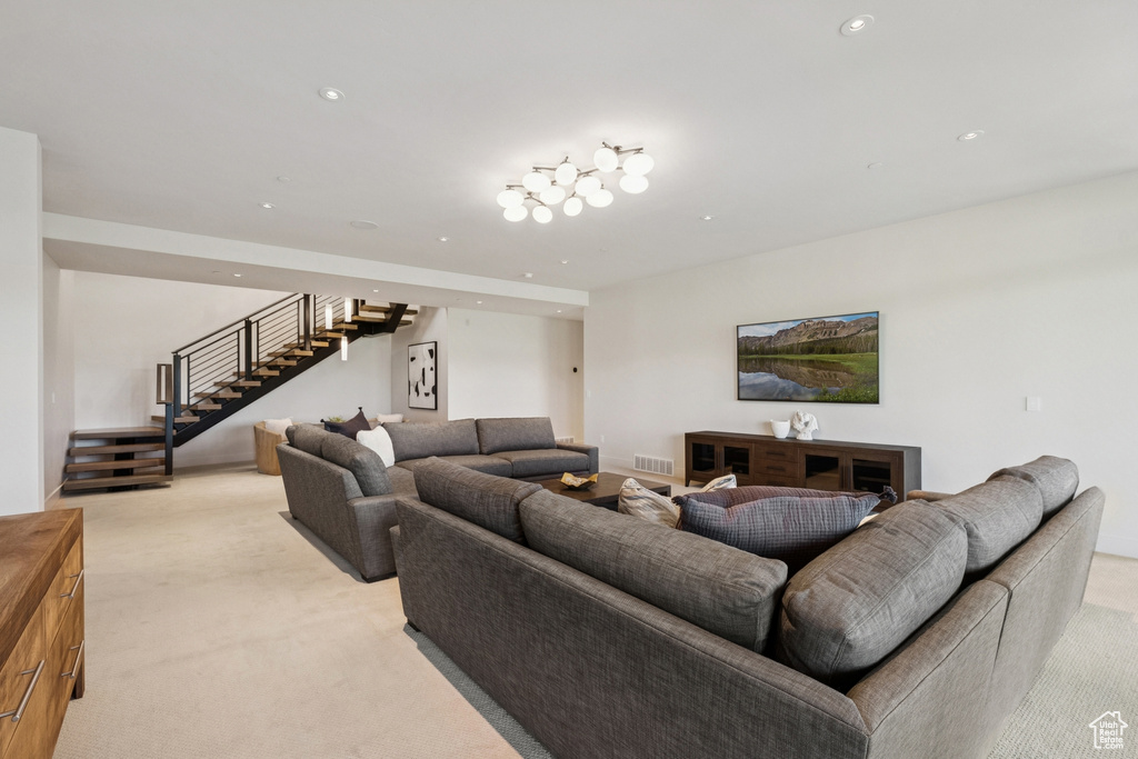 Living area with light colored carpet, stairway, and recessed lighting