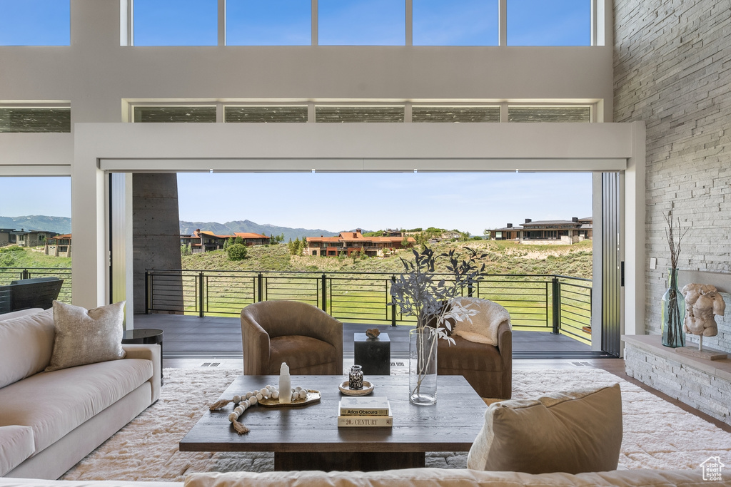 Living room with a towering ceiling, wood finished floors, and a mountain view