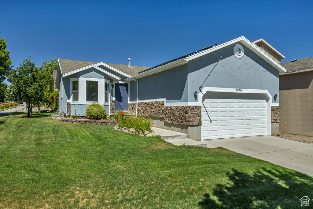 Single story home with stone siding, stucco siding, a garage, and driveway