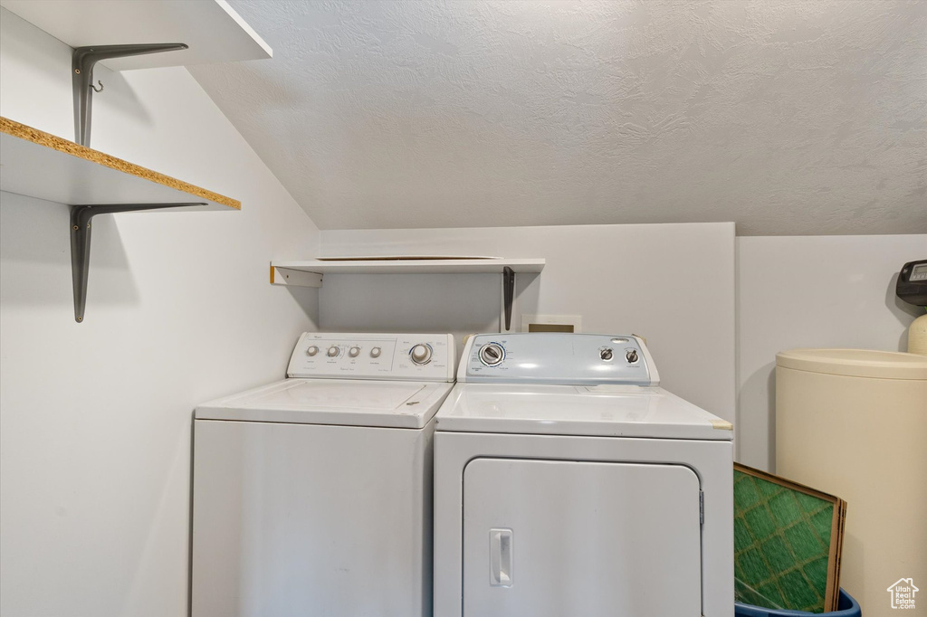 Washroom featuring laundry area, a textured ceiling, and independent washer and dryer