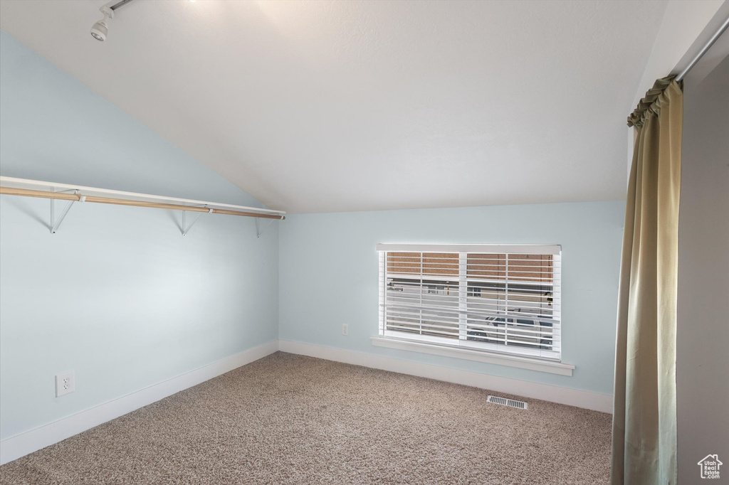 Walk in closet featuring carpet floors, lofted ceiling, and visible vents