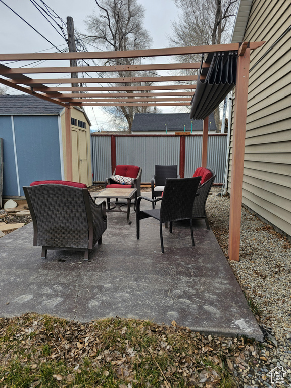 View of patio / terrace featuring fence, an outdoor structure, a shed, outdoor lounge area, and a pergola