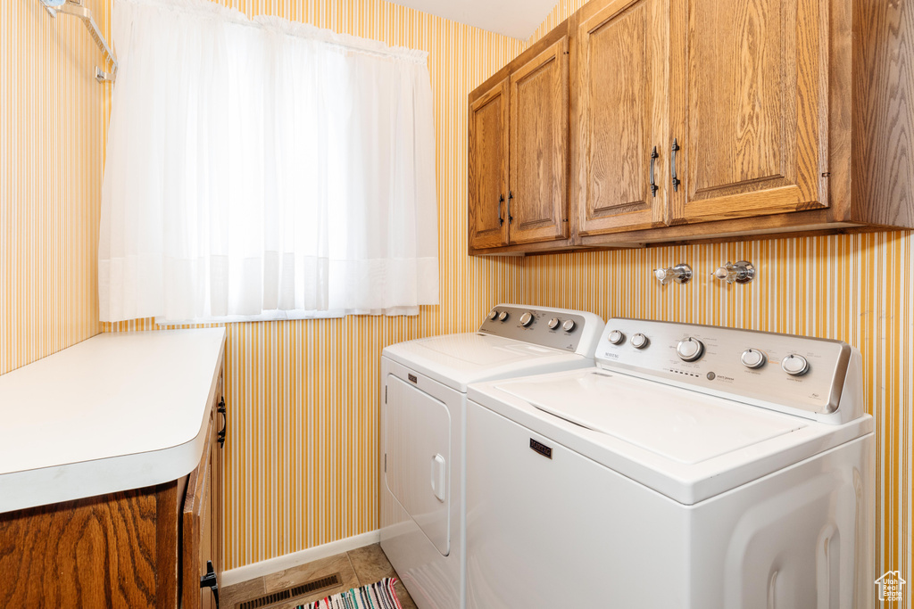 Laundry area featuring washer and dryer and cabinets