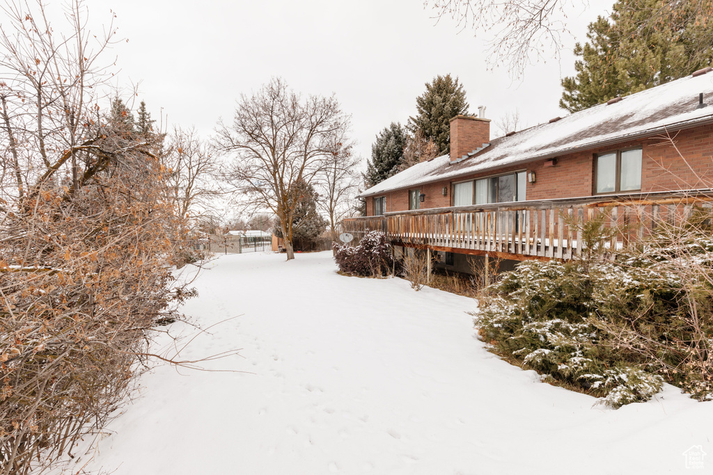 Snowy yard featuring a deck