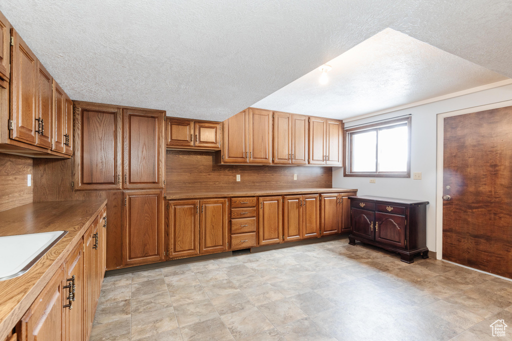 Kitchen with sink, a textured ceiling, and decorative backsplash