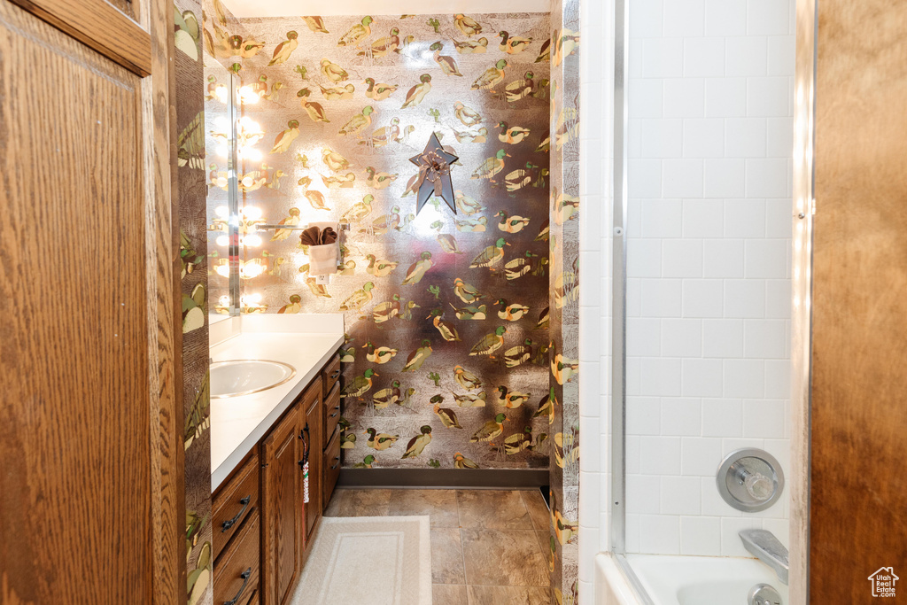 Bathroom with tiled shower / bath combo and vanity