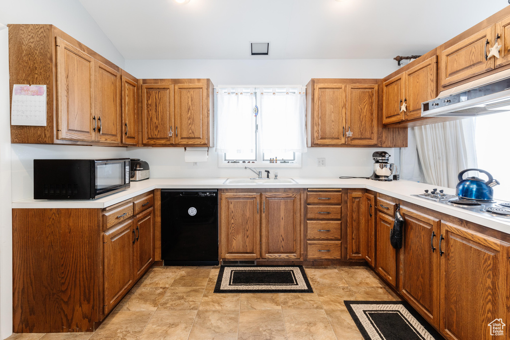 Kitchen featuring vaulted ceiling, sink, and black appliances