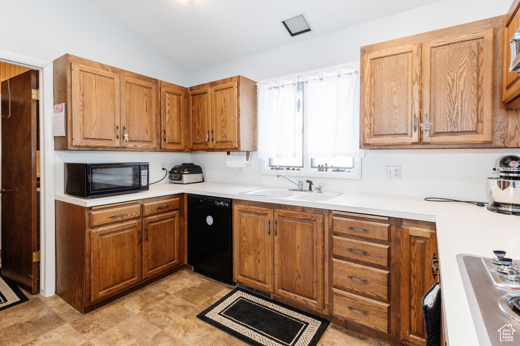 Kitchen with sink, vaulted ceiling, and black appliances