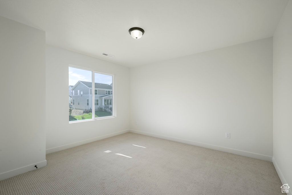 Unfurnished room featuring light carpet