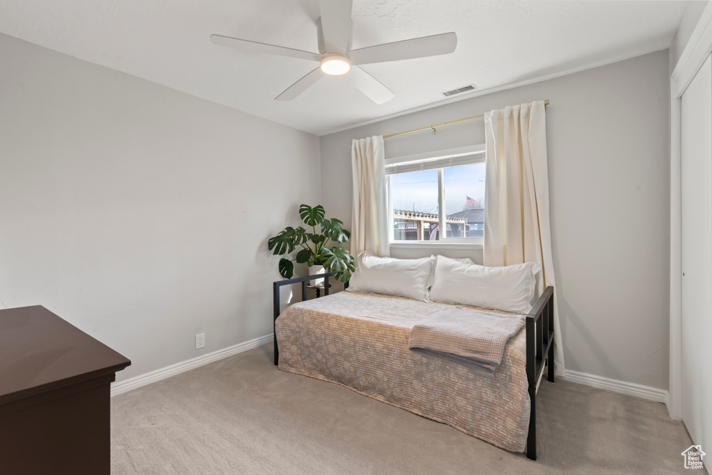 Carpeted bedroom with ceiling fan