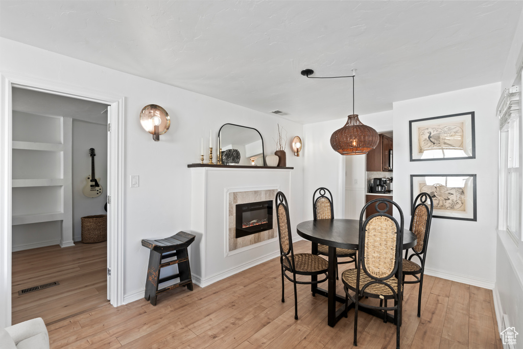 Dining room with light hardwood / wood-style floors and built in features