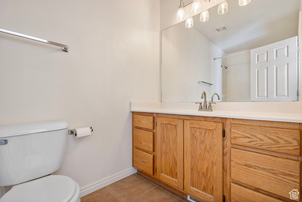 Bathroom with tile patterned flooring, vanity, and toilet