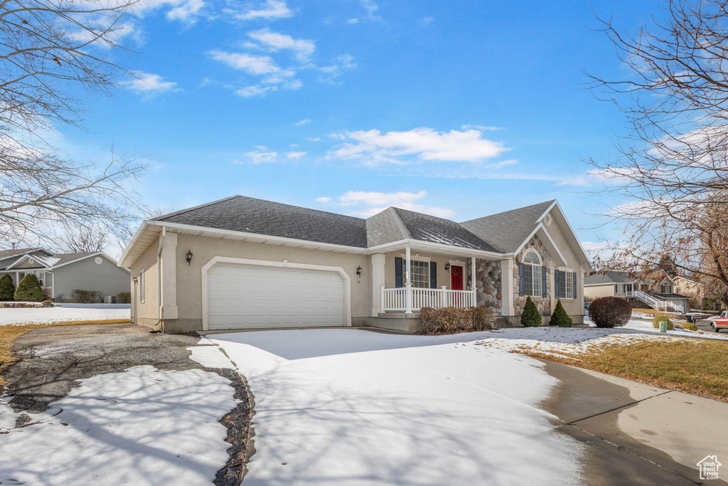 Ranch-style house featuring a porch and a garage