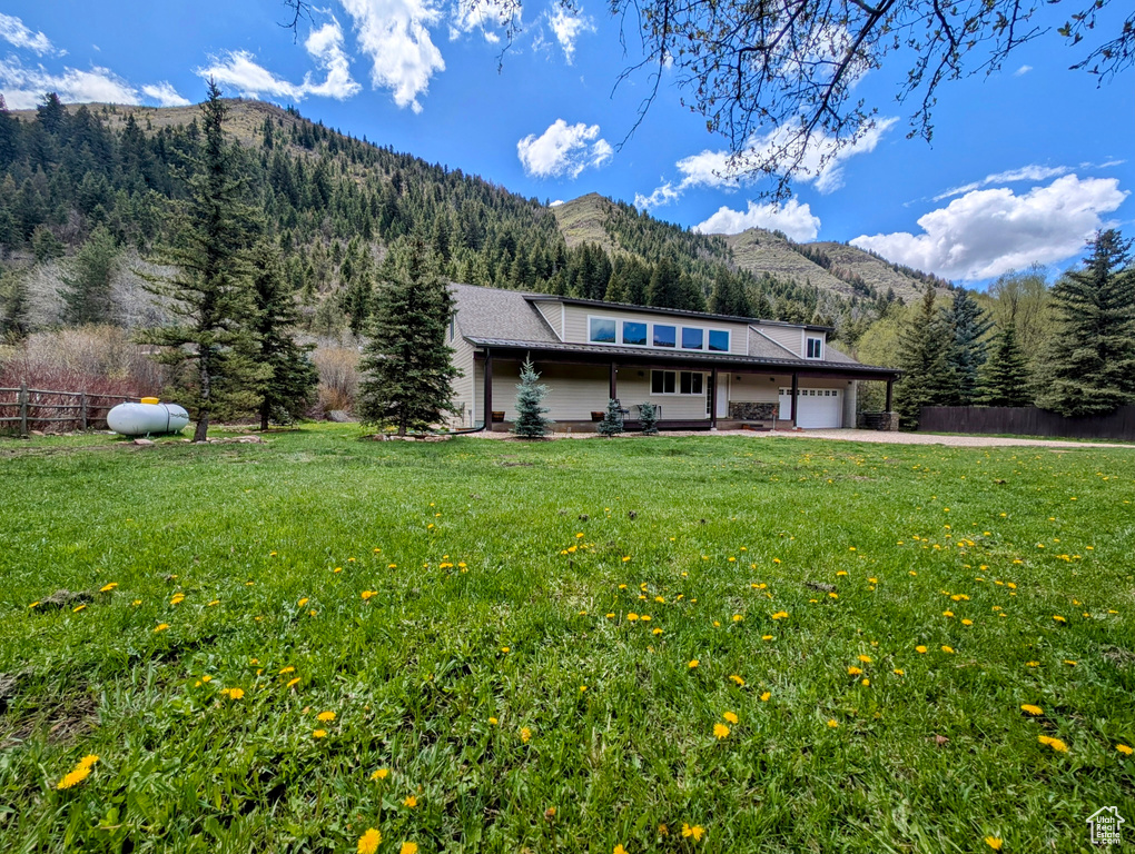 View of front of house featuring a mountain view, an attached garage, and asphalt driveway