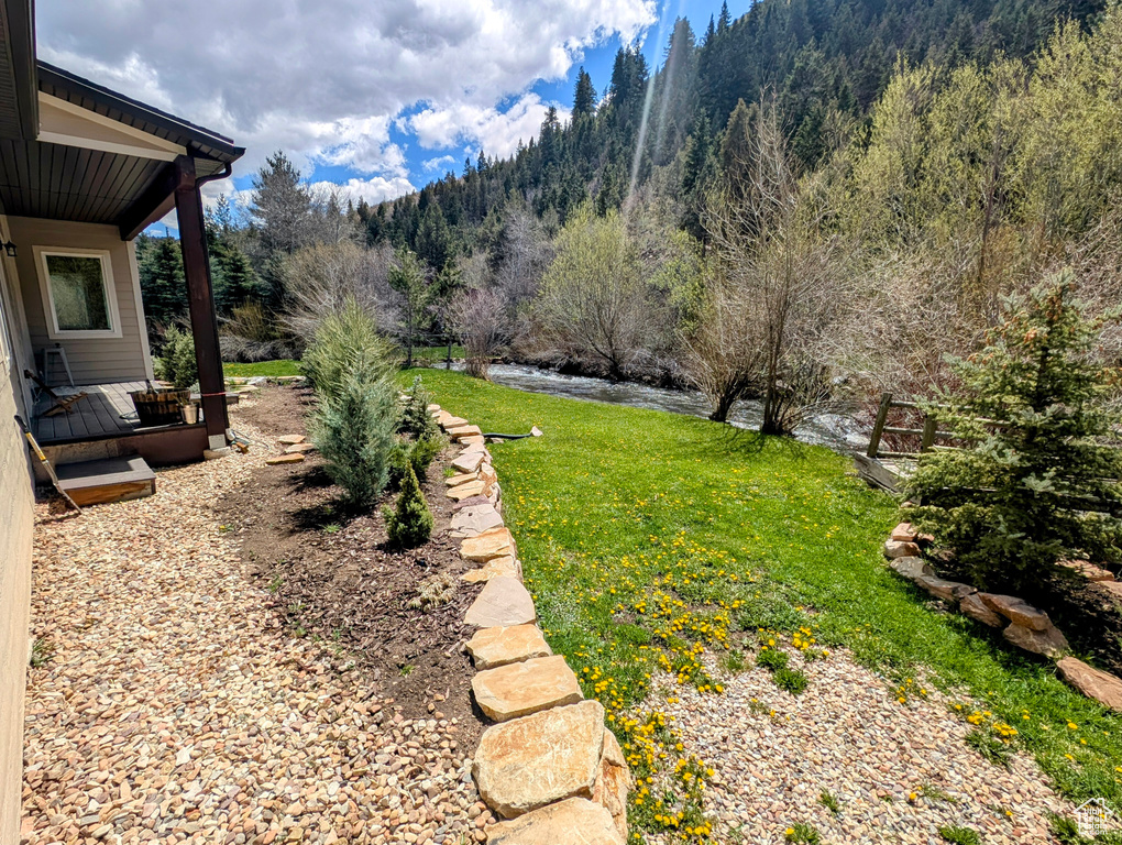 View of green lawn featuring a view of trees and a mountain view