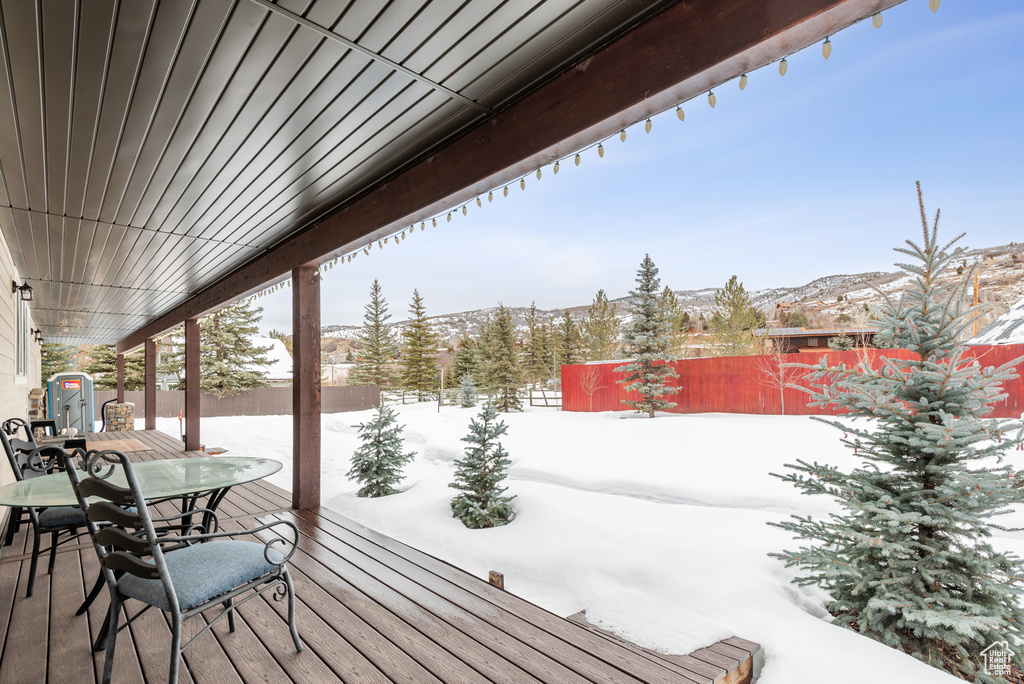 Snow covered deck featuring a mountain view