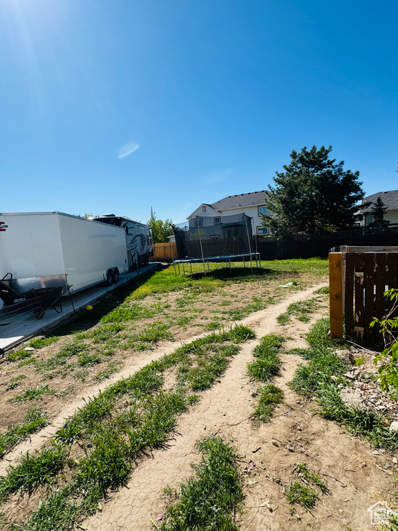 View of yard featuring fence and a trampoline