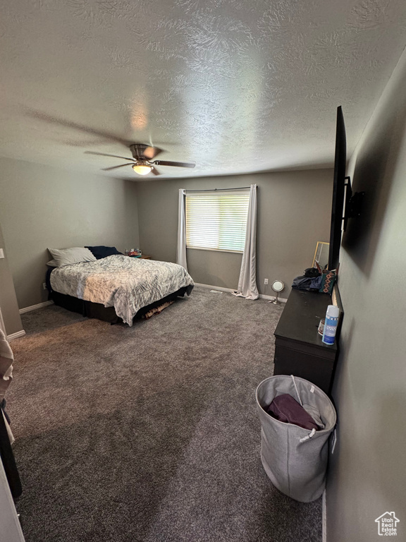 Bedroom featuring a textured ceiling, a ceiling fan, carpet flooring, and baseboards
