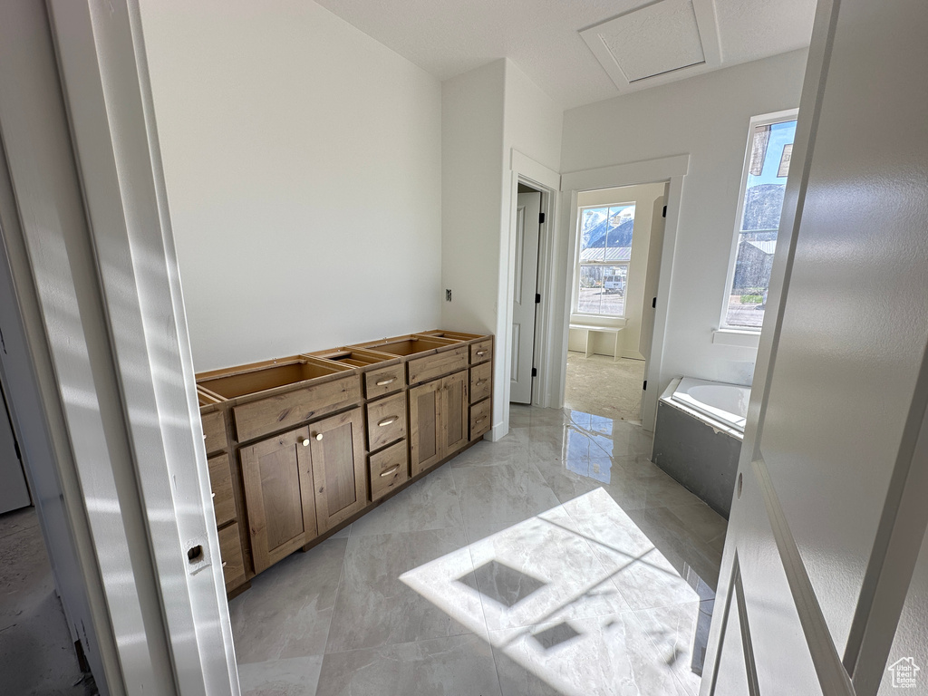 Bathroom featuring a garden tub and marble finish floor