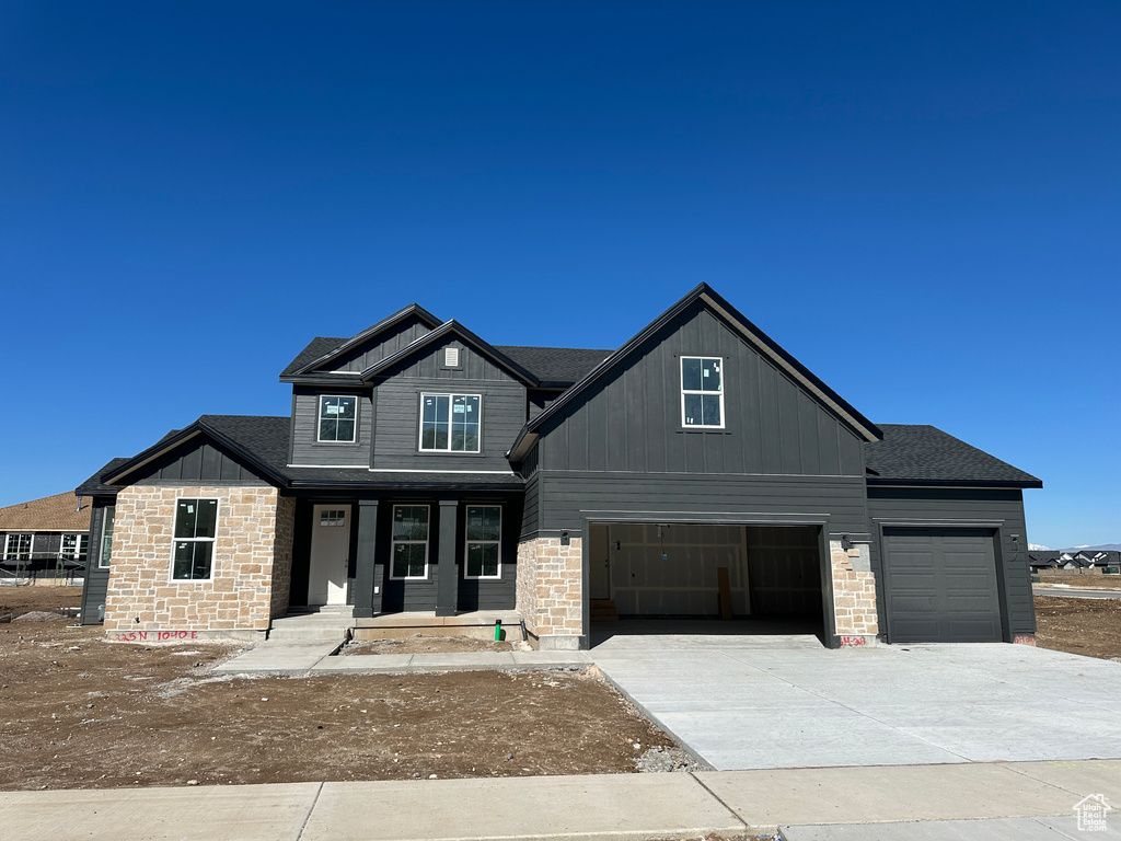 Craftsman house featuring concrete driveway, board and batten siding, a porch, stone siding, and a garage