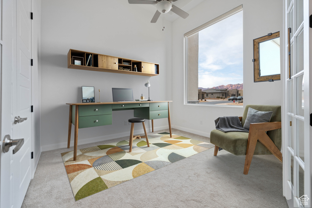 Carpeted office with ceiling fan and built in desk