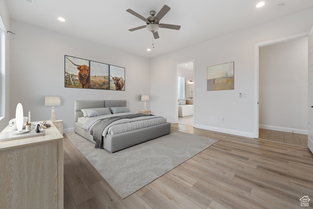 Bedroom with light hardwood / wood-style floors, ensuite bath, and ceiling fan