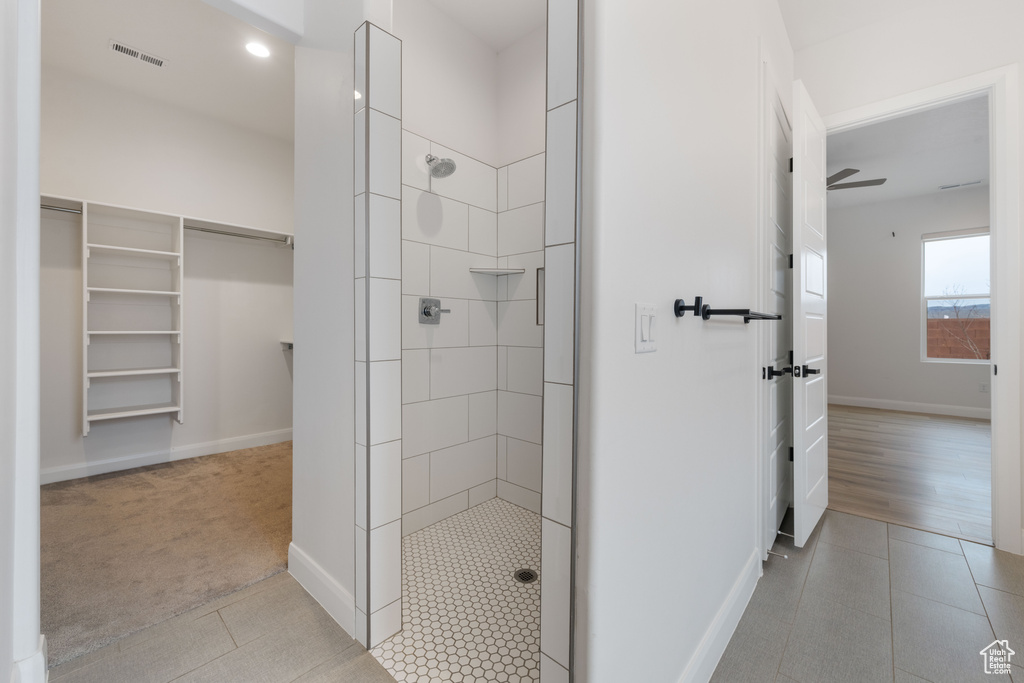 Bathroom with tile patterned flooring and a tile shower