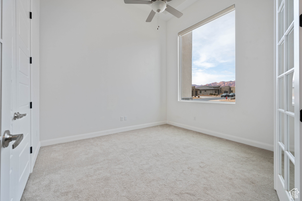 Spare room with light carpet and ceiling fan