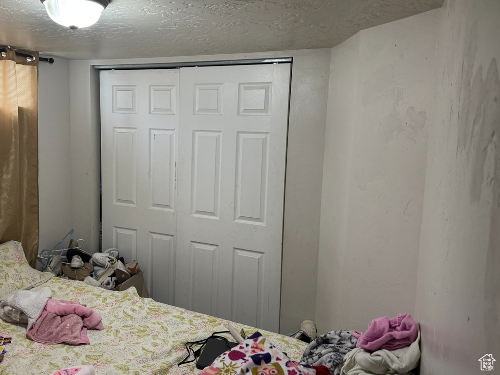 Bedroom with a closet and a textured ceiling