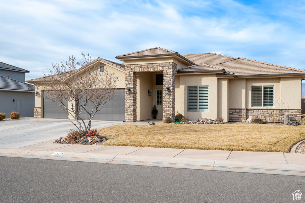 View of front of property with a front lawn and a garage
