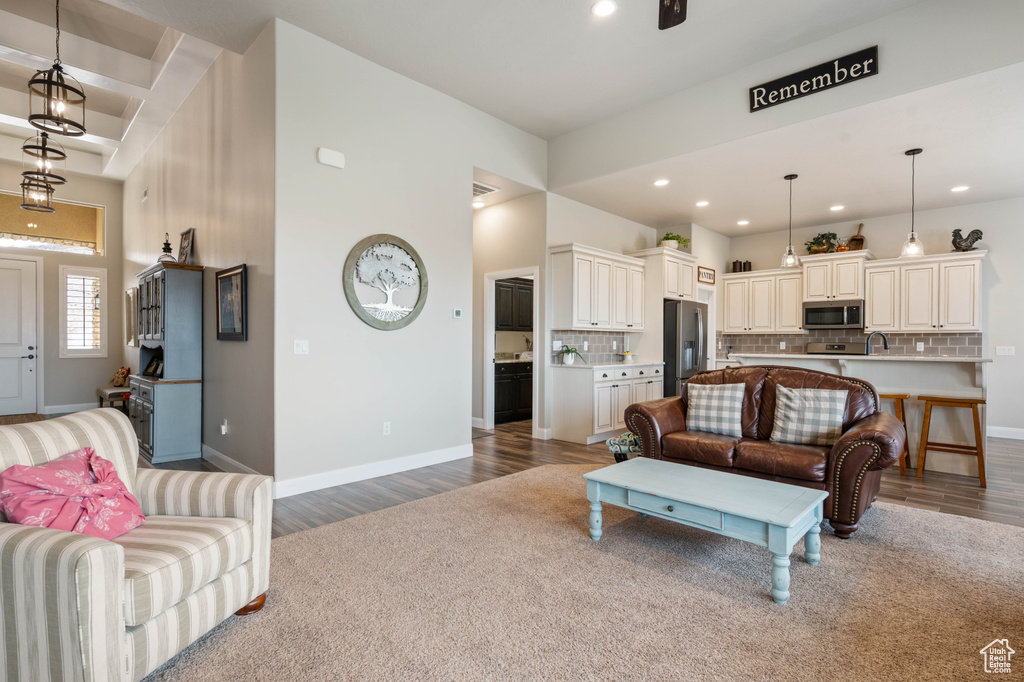 Living room with sink, a high ceiling, and hardwood / wood-style floors