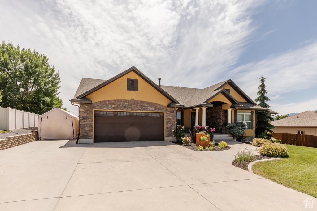 Craftsman inspired home with driveway, stone siding, and stucco siding