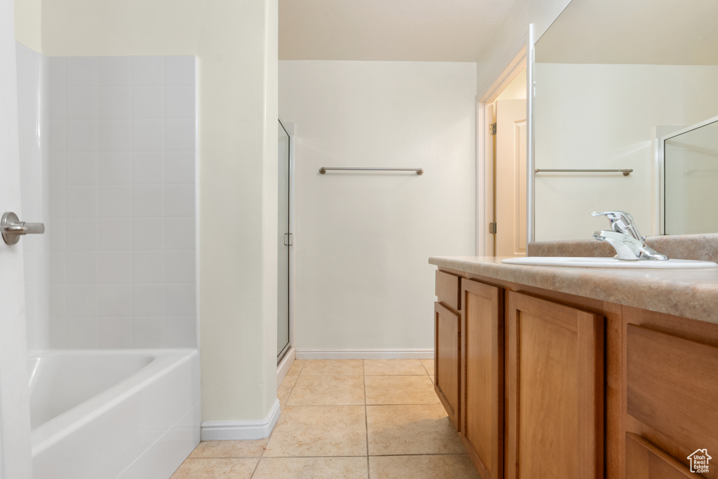 Bathroom with tile patterned floors, plus walk in shower, and vanity