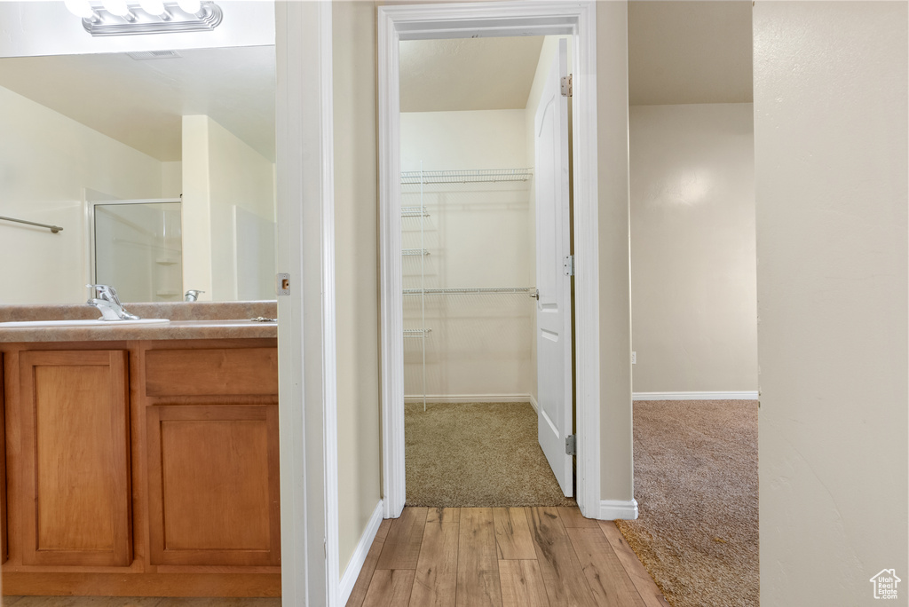 Bathroom with an enclosed shower, vanity, and hardwood / wood-style floors